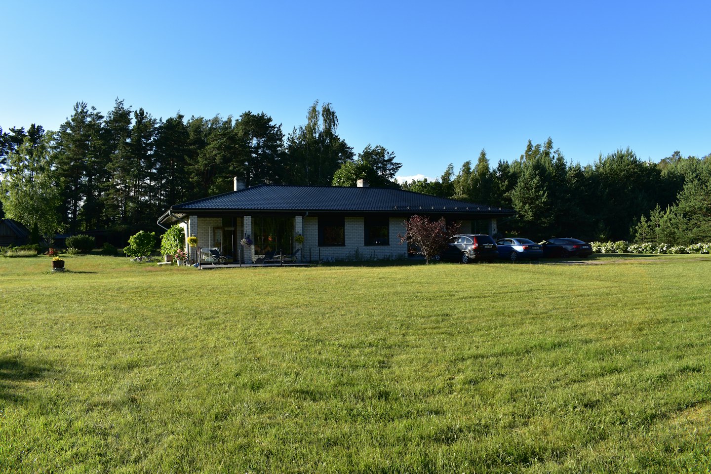 Modern brick house with a tiled roof sits on a lawn.