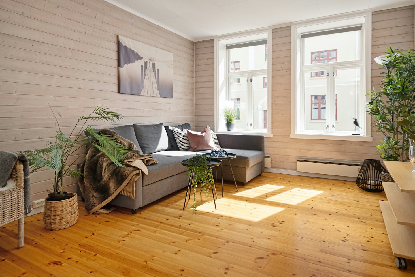 Modern living room with a grey sofa and wooden walls.
