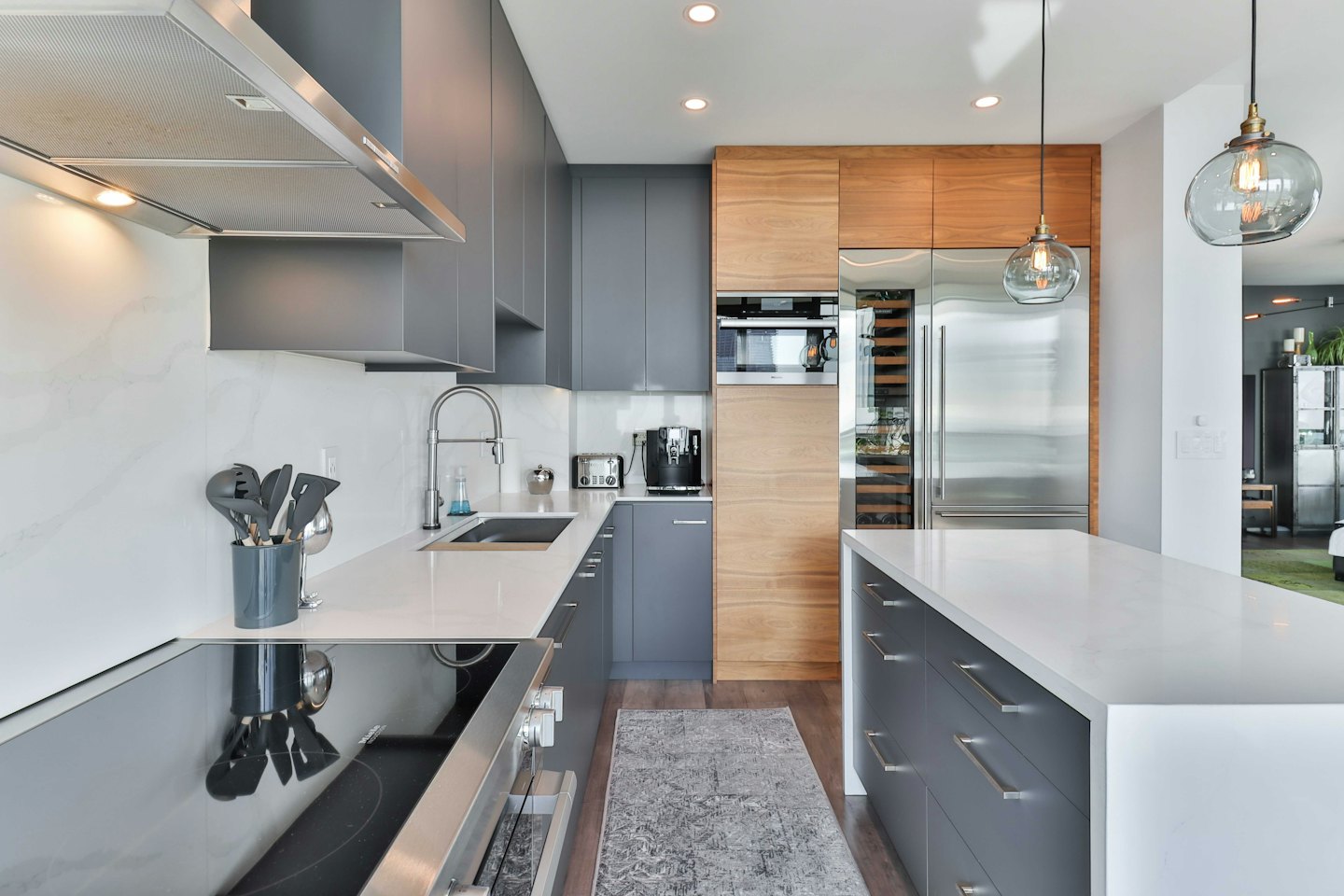 Modern kitchen with grey cabinets and stainless steel appliances.